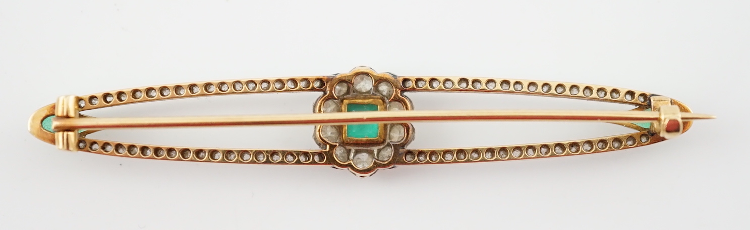A Belle Epoque gold and platinum, emerald and round cut diamond cluster set elliptical bar brooch
